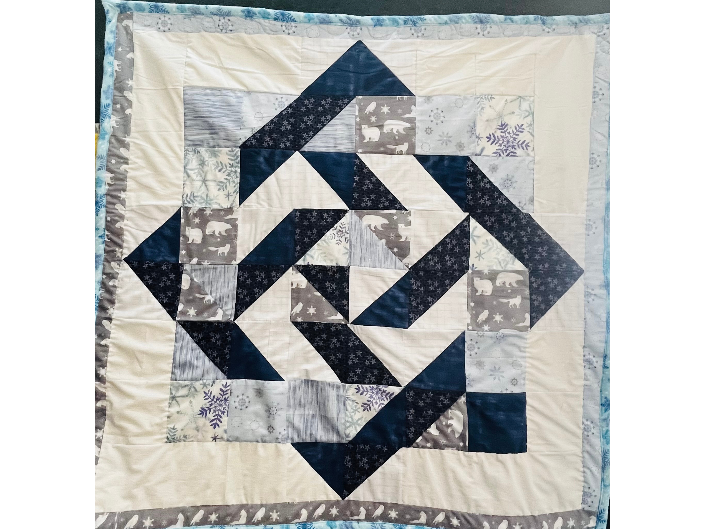 Handmade winter-themed quilt — geometric patchwork in navy, grey, and white